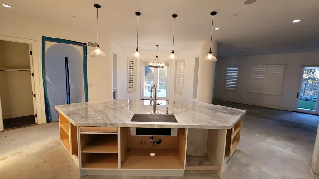 Large kitchen island with a newly installed stone countertop during construction