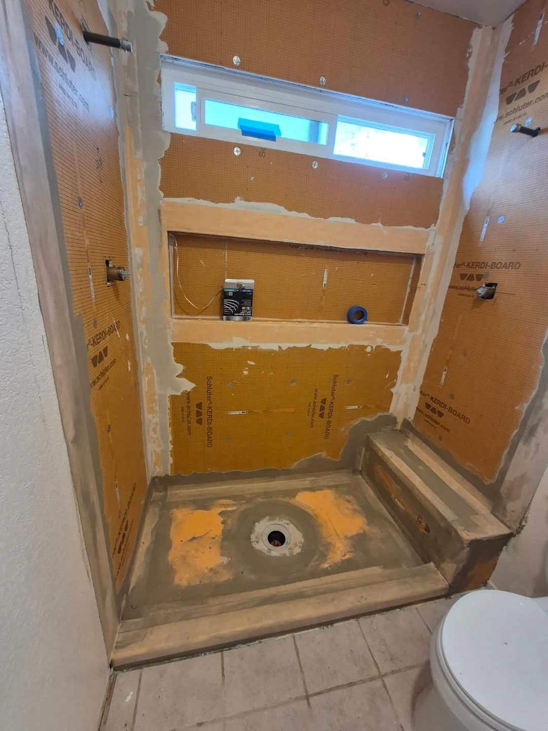 Schluter waterproofing installed around a shower niche and bench