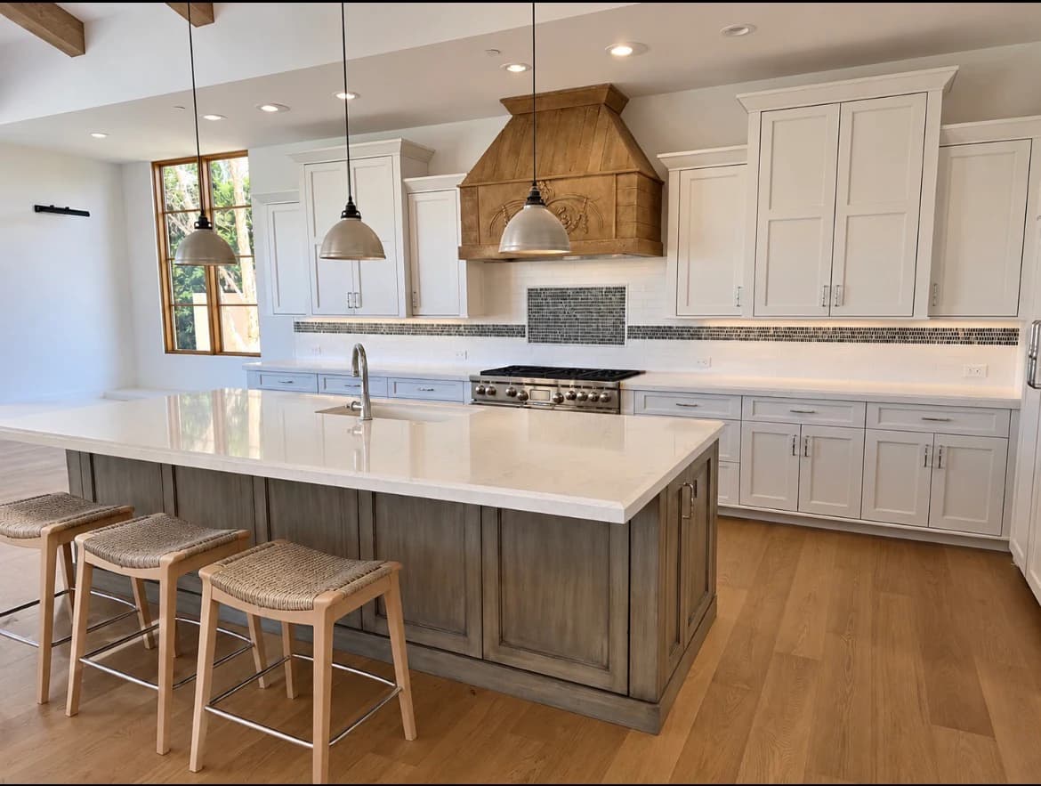 Completed kitchen with a tiled backsplash, stone countertops, and a large island